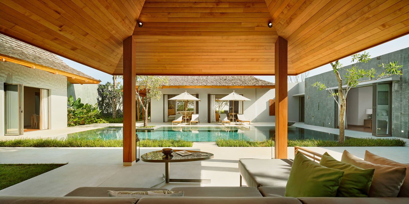 Teak-ceilinged terrace looking across an Anchan pool